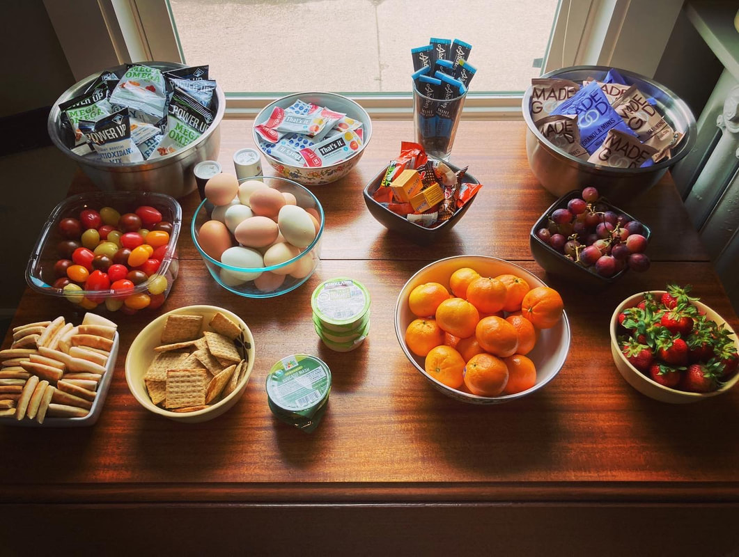 Individual snacks laid out on a table in the kitchen.